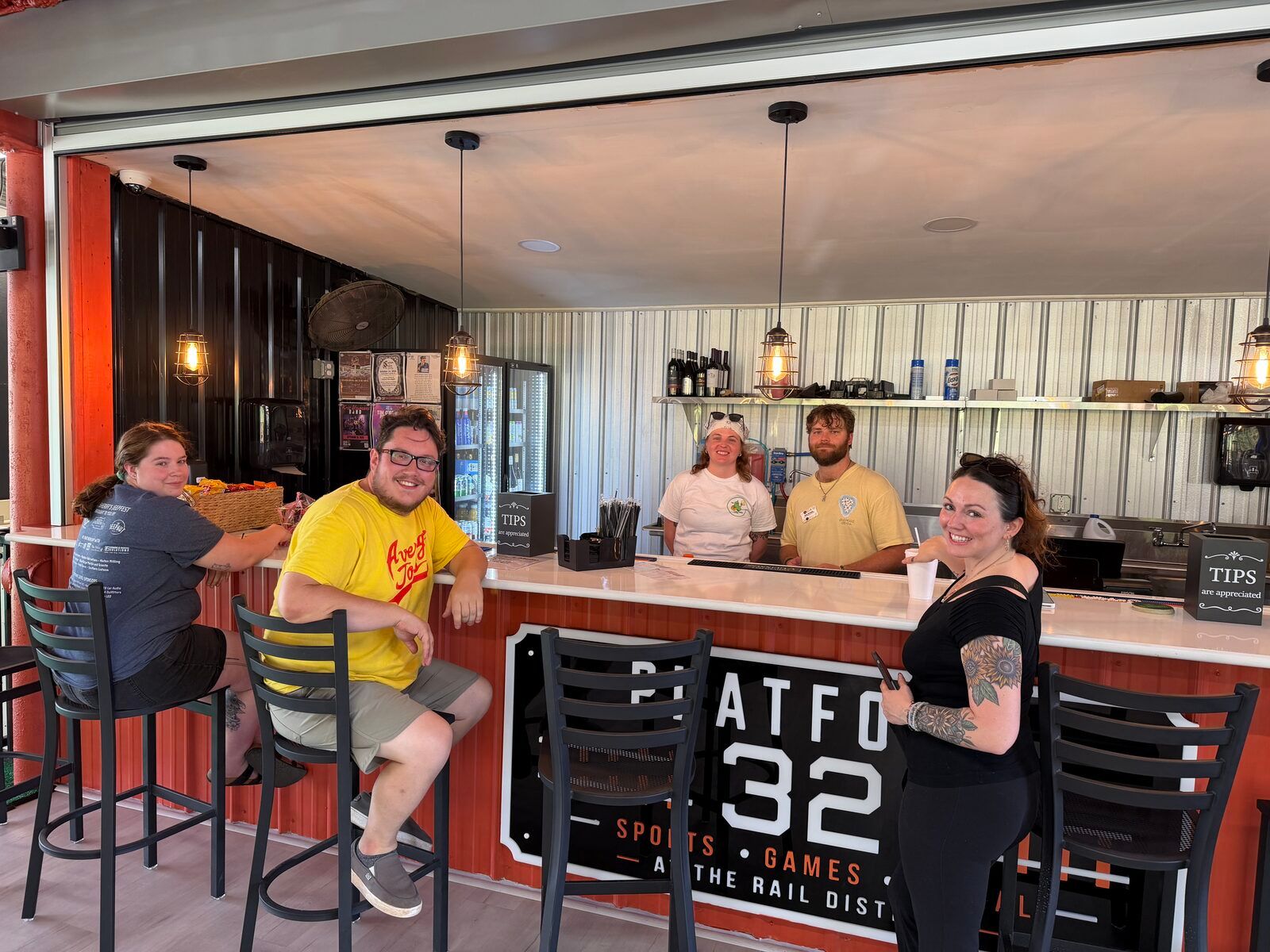 Guests at the Platform 32 bar, with the venue's sign on the bar front.